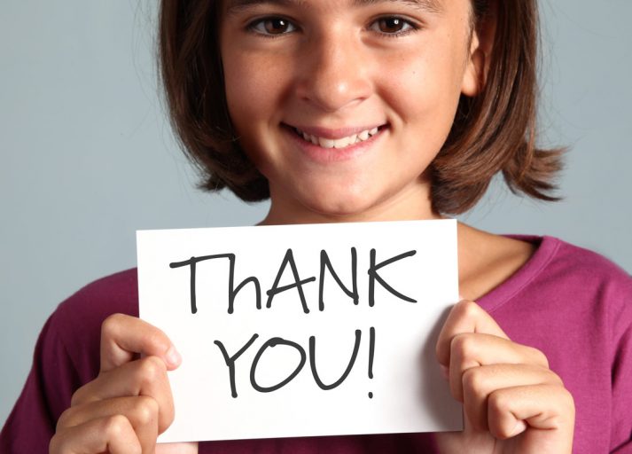 The Dreaded Mitzvah Thank You Notes girl holding a thank you card.